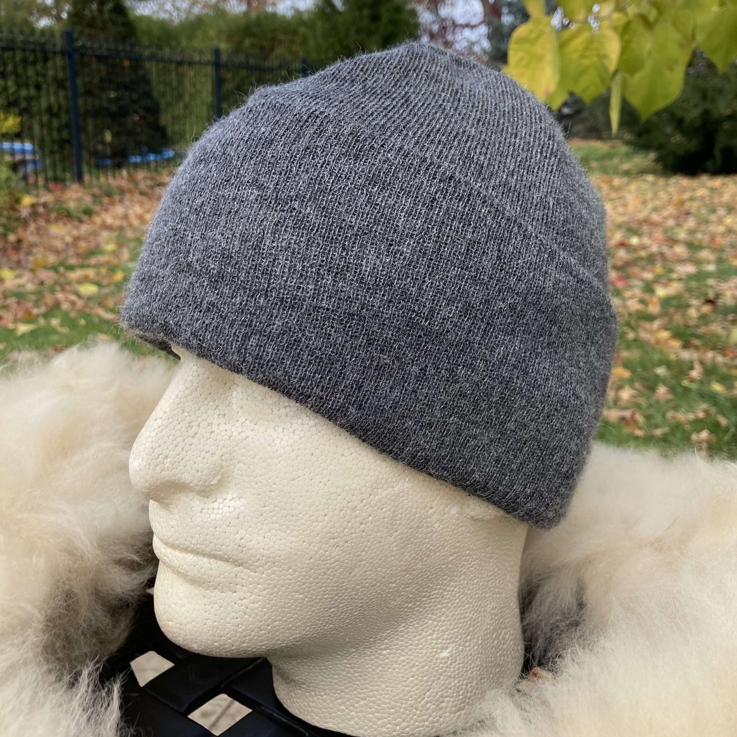 Grey alpaca beanie on a mannequin head with a blurred outdoor background
