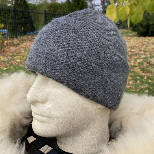Grey alpaca beanie on a mannequin head with a blurred outdoor background