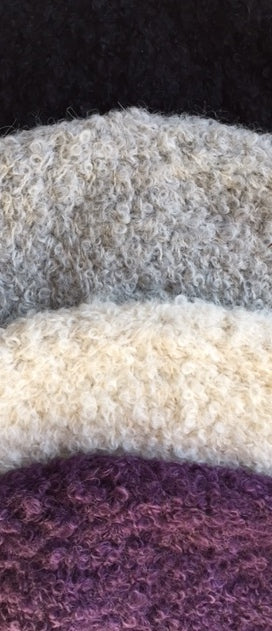 Boucle yarn alpaca fabric showing 4 colours - black, silver grey, ivory, and purple.