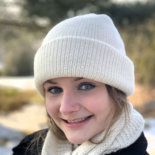 Woman wearing an ivory alpaca ribbed hat and alpaca scarf outdoors