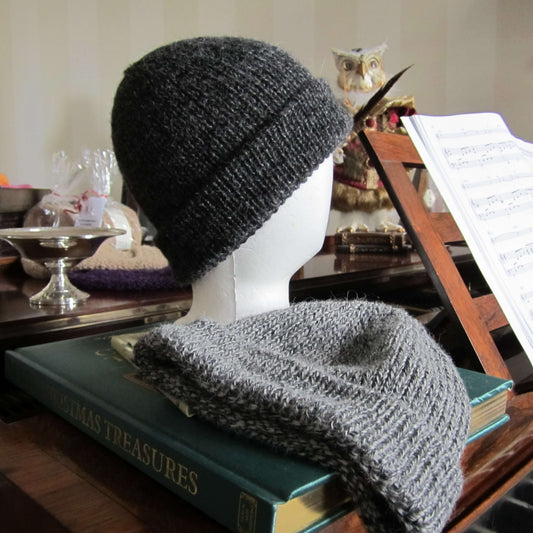 Gray rib knit alpaca hat on a mannequin head with a book in the background