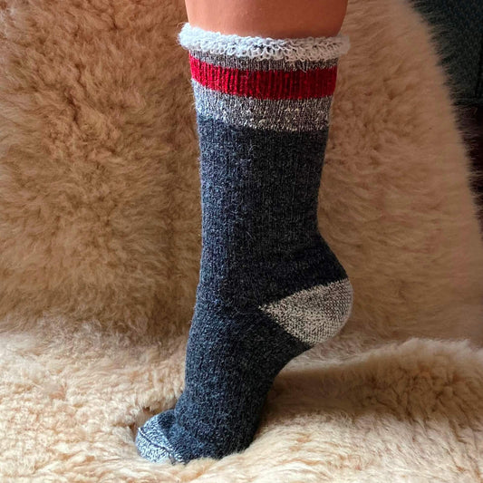 Heavy weight alpaca sock with red stripe pattern on a fluffy beige surface