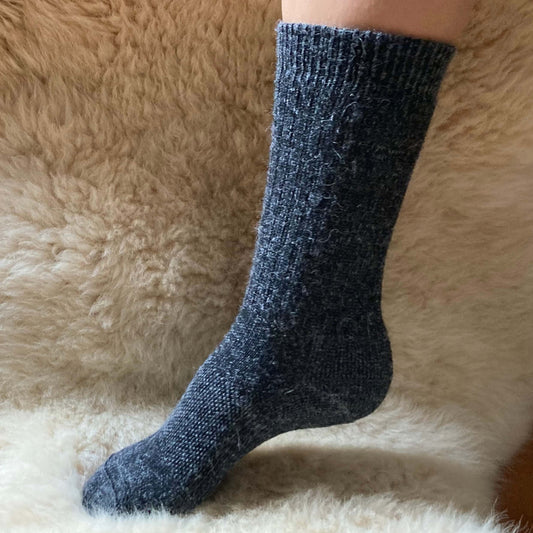 Technical knit alpaca sock on a fluffy beige surfac