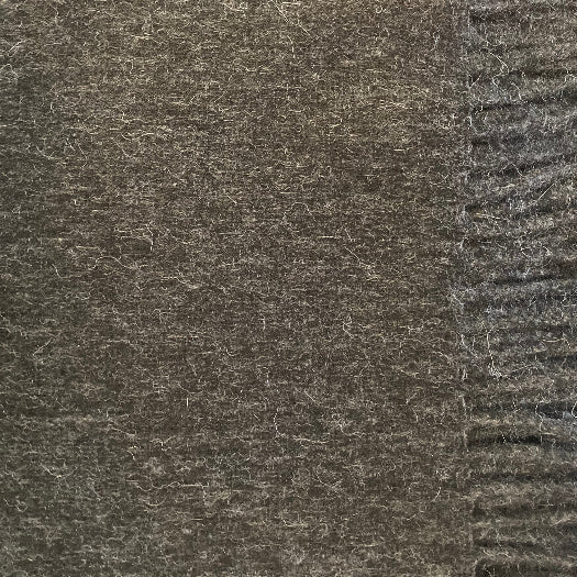 Close-up of a textured grey alpaca throw with a fringe