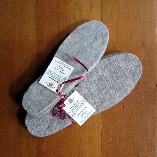 Two pairs of Alpaca insoles on wooden background