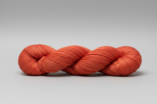 Orange skein of yarn on a white background