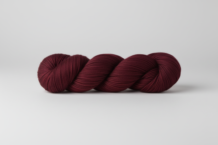 Maroon skein of yarn on white background
