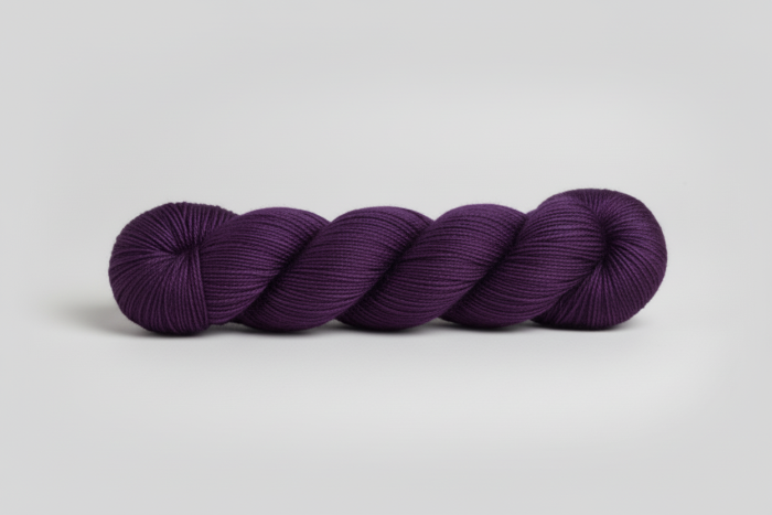 Dark purple yarn skein on a white background