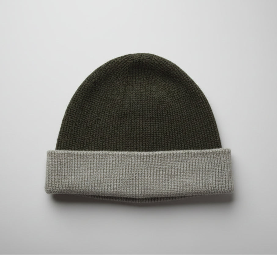 Moss green and silver grey alpaca hat on a light gray background